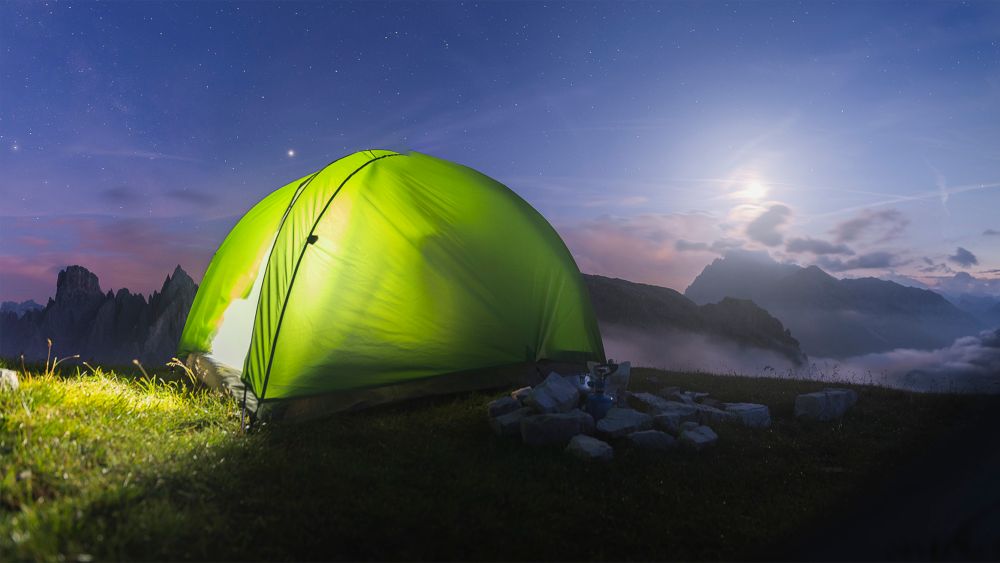 Tenda illuminata dalla luna durante la notte